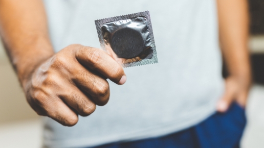 Man holding a condom packet