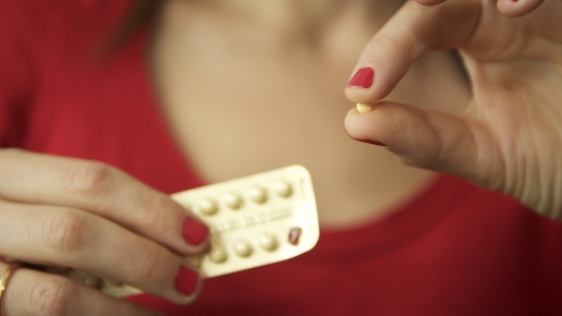 Woman taking a pill from a blister pack